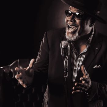 An artist with an electric guitar is at the center of the graphic. The design celebrates the 50th anniversary of "Virgin Killer".