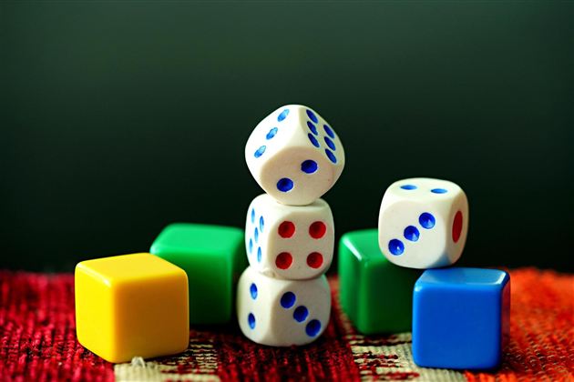 Colorful play cubes in various shapes are on a carpet. The cubes are designed in white, blue, green, and yellow.