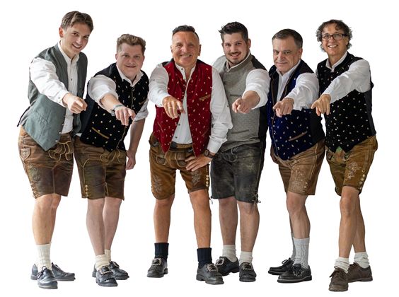 Six men in traditional Bavarian attire stand side by side, pointing forward with their fingers. They are wearing lederhosen and colorful vests that appear festive and inviting.