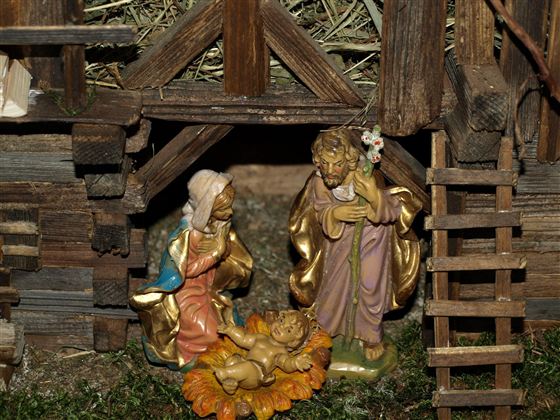 Eine Krippe mit Figuren, die die Geburt Jesus darstellen. Die Szene zeigt Maria, Joseph und das neugeborene Kind in einer liebevoll gestalteten Umgebung.