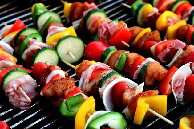 Gegrillte Spieße mit buntem Gemüse und Fleisch auf einem Grill. Eine leckere und appetitliche Mahlzeit im Freien.