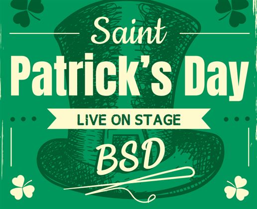 Een groep vrolijke skiërs staat samen en houdt verschillende vlaggen vast. Ze dragen winterkleding en glimlachen naar de camera.