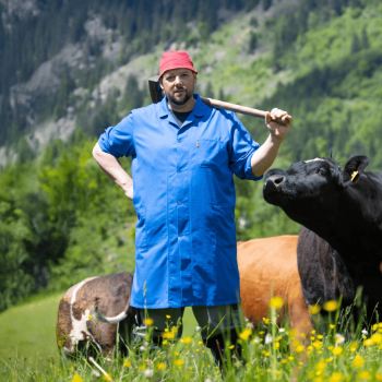 Een man ligt op de grond met een verbaasde gezichtsuitdrukking. Hij draagt elektroden en er liggen een reddingsring en een rode tas naast hem.