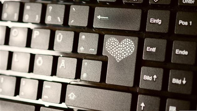 Eine Computertastatur mit einer speziellen Taste, die ein Herzmotiv zeigt. Die Tasten sind schwarz und gut lesbar.