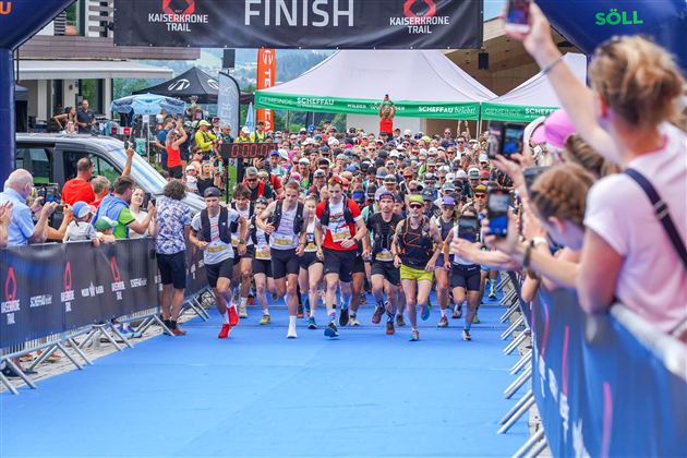 A large sporting event with many participants at the start. The atmosphere is lively and numerous spectators cheer on the runners.