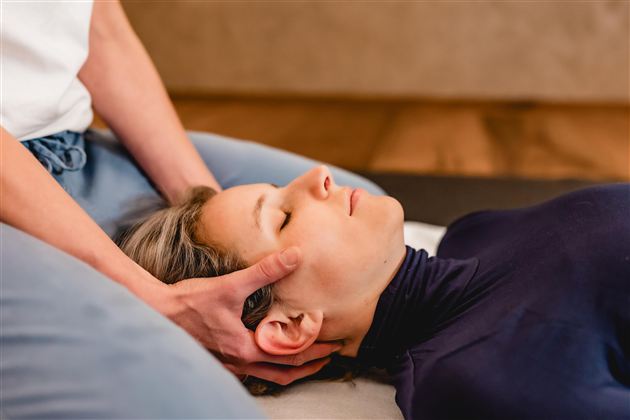Eine Person erhält eine entspannende Massage im Nackenbereich. Die Atmosphäre wirkt beruhigend und friedlich.