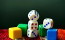 Colorful play cubes in various shapes are on a carpet. The cubes are designed in white, blue, green, and yellow.