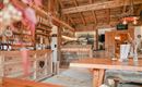 Eine gemütliche Holzbar mit einem einladenden Interieur. Im Hintergrund sind Regale mit Getränken und eine schöne Theke zu sehen.
