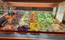 Ein Salatbuffet mit verschiedenen bunten Gemüsesorten und Dressings. Es bietet eine Vielzahl von gesunden Optionen in klaren Behältern.