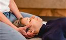 Eine Person erhält eine entspannende Massage im Nackenbereich. Die Atmosphäre wirkt beruhigend und friedlich.