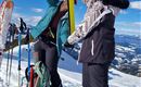 Zwei Personen bereiten sich im Schnee auf das Skifahren vor. Sie überprüfen ihre Ausrüstung vor einer malerischen Berglandschaft.