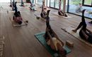 A calming yoga class in a cozy wooden room. Participants practice in a relaxed atmosphere with dim lighting.