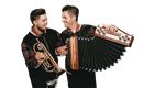 Zwei Musiker stehen nebeneinander und lächeln sich an. Der eine hält eine Trompete und der andere ein Akkordeon.