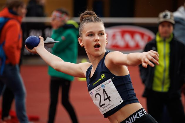 Een jonge atlete werpt een speer tijdens de training. Ze draagt een sportoutfit en ziet er gefocust uit.