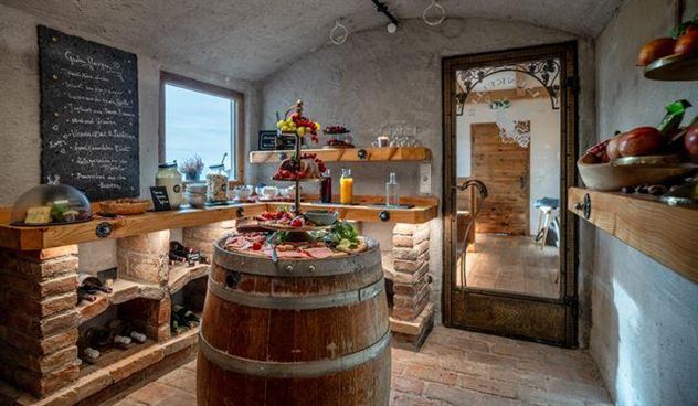 A cozy kitchen with rustic wooden furniture and a wooden countertop. On the table lies a selection of fresh food and snacks.