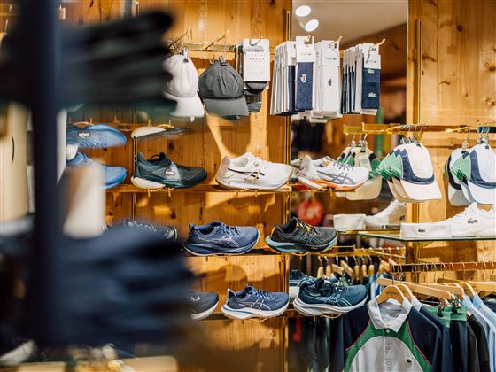 Een sportwinkel met een selectie van schoenen en accessoires. De planken zijn goed gevuld met verschillende kleuren en modellen.