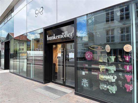 A modern store with a large glass front. It is a Hunke Müller shop that displays underwear in the window.