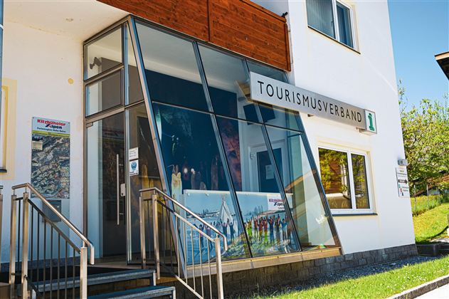Een modern toeristenbureau met een grote glazen gevel. Het toont informatie en aanbiedingen voor bezoekers.