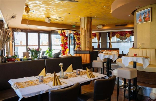 A stylish restaurant with modern furniture and tasteful decoration. The tables are elegantly set, and the atmosphere feels inviting.