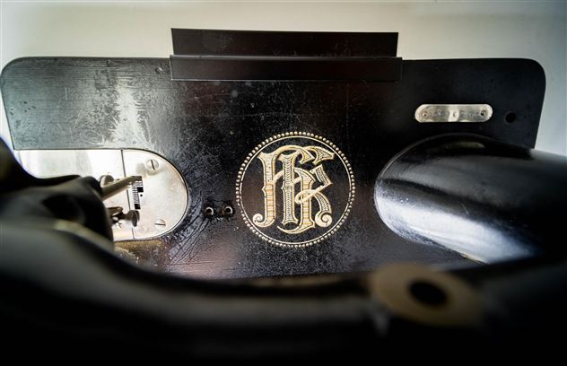 Eine Nähmaschine mit einem eleganten Logo. Der Fokus liegt auf dem schwarzen Gehäuse und den Details der Maschine.