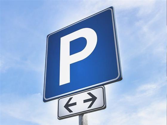 A parking sign with a large white "P" on a blue background. Below, there are arrows pointing left and right.