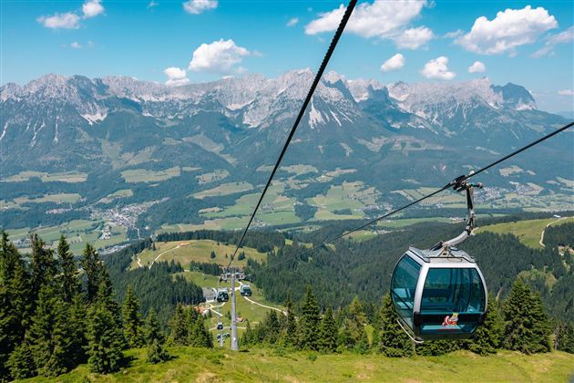 Uitzicht vanuit een gondel van de Brandstadlbahn op het bergmassief van de Wilde Kaiser en het groene dal.