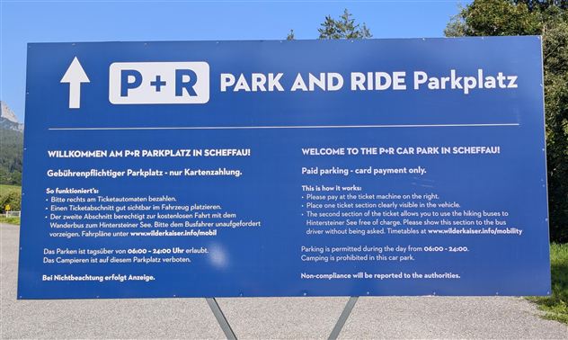 An information sign for the P+R parking lot in Scheffau. It contains instructions for the use and payment of the parking lot.
