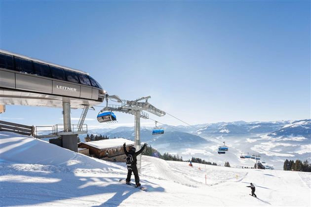 An impressive ski resort with a gondola and snow-covered slopes. The clear blue sky provides a dreamy backdrop for winter sports enthusiasts.
