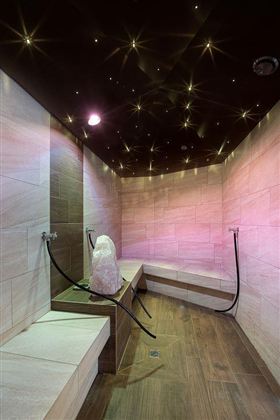 Een moderne stoomruimte met zachte houten oppervlakken en een sprankelende sterrenhemel. Zachte kleuren en een ontspannen sfeer nodigen uit tot welzijn.