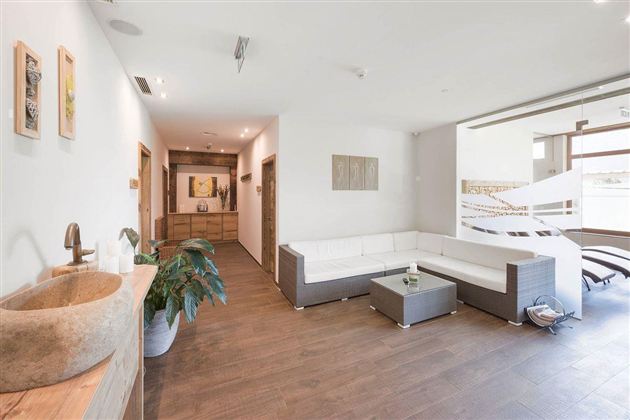 Een moderne woonkamer met een heldere, uitnodigende sfeer. Er is een stijlvolle bank, natuurlijke planten en veel ruimte voor ontspanning.