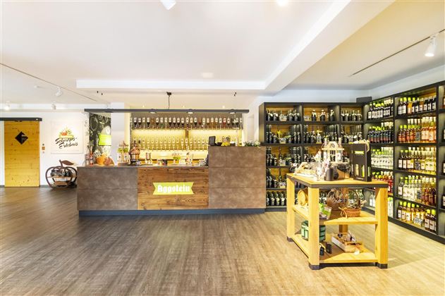 Een moderne winkel met een goed gesorteerde bar en planken vol dranken. De houten planken en de receptiebalie creëren een uitnodigende sfeer.