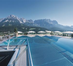 Een adembenemend infinity-pool met uitzicht op majestueuze bergen. De omgeving is rustig en uitnodigend, ideaal om te ontspannen.