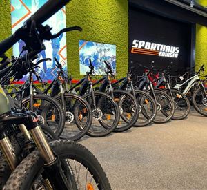 Een selectie van mountainbikes in een sportwinkel. Op de achtergrond is het logo van "Sporthaus Edinger" te zien.