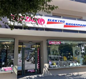 Een elektronicawinkel met grote etalages en een opvallend bord. De gevel is modern en uitnodigend.