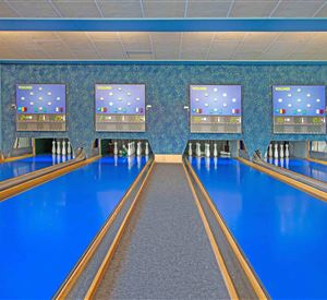 Een bowlingbaan met lichtblauwe banen en digitale scoreborden. De ruimte is helder en modern ingericht.