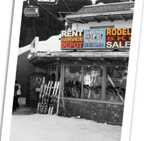 A sports shop in the snow that rents and sells ski equipment. In the background, a ski lift is visible.