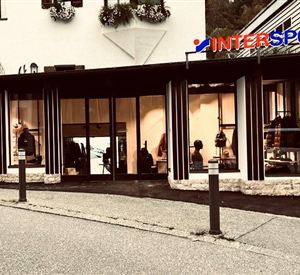 A modern sports store with large windows and a clear view of the displays. The sign "INTERSPORT" is clearly visible above the entrance.