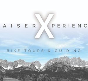 An image titled "KaiserXperience". It shows the mountains in a beautiful landscape, with the focus on bike tours and guiding.