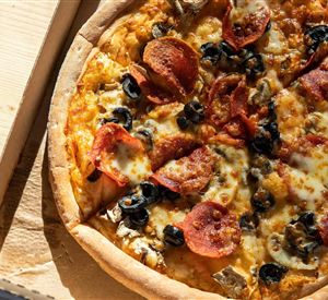 Een heerlijke pizza met kaas, salami en zwarte olijven. Hij ligt in een pizzadoos.