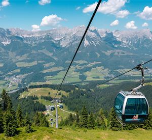 View from a gondola of the Brandstadlbahn of the Wilder Kaiser mountain massif and the green valley.