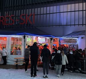 Een logo van "Der Kaiser", een après-ski-bar in Scheffau. Het toont een gestileerde berg en de tekst in gouden en zwarte letters.