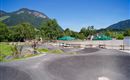 Eine moderne Skate-Anlage mit geschwungenen Rampen und einer schönen Berglandschaft im Hintergrund. Die Umgebung ist grün und einladend, ideal für Outdoor-Aktivitäten.