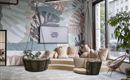 A modern room with a large wall design of leaves. There are comfortable seating areas and swing chairs that create an inviting atmosphere.