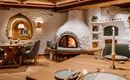 Een gezellig restaurant met een open haard en rustieke houten decoratie. De tafels zijn elegant gedekt en creëren een uitnodigende sfeer.