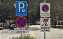 Ein Parkbereich mit verschiedenen Verkehrsschildern. Es gibt Hinweise zu Parkregeln und einem Campingverbot.