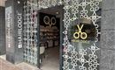 A hair salon with the sign "HAIRLODGE" and a modern entrance. The windows are decorated with stylish patterns and scissor symbols.