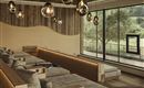 A modern, cozy living room with wood paneling and stylish lamps. Large windows offer a view of the greenery.