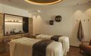 An elegant spa with two treatment beds and warm colors. The decor is modern and inviting.