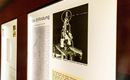 Ein Ausstellungsstück zeigt eine historische Erfindung mit einer technischen Vorrichtung. Daneben befindet sich ein Text, der die Erfindung beschreibt.