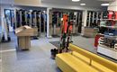 Ein moderner Skishop mit Regalen voller Skiausrüstung. Im Vordergrund steht ein gelbes Sofa und ein Empfangstresen.